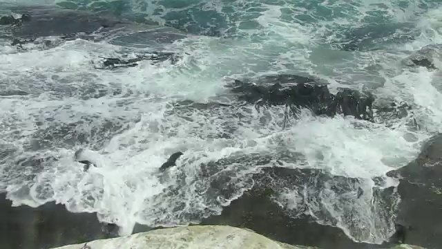 跳岩企鹅在岩石上跳跃，然后被巨浪淹没视频素材