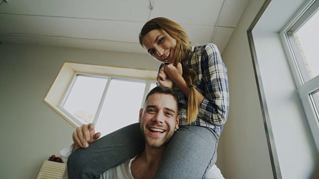 一对幸福微笑的美丽夫妇用智能手机拍自拍照，女孩坐在男人的脖子上视频素材