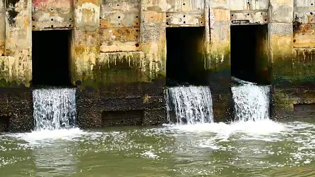 雨后日常生活视频。水从城里的一条运河流向大海。以水浸概念来排水及防止城市水浸。视频素材