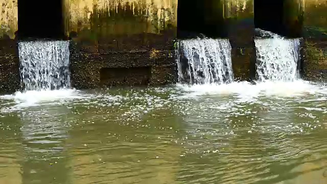 雨后日常生活视频。水从城里的一条运河流向大海。以水浸概念来排水及防止城市水浸。视频素材