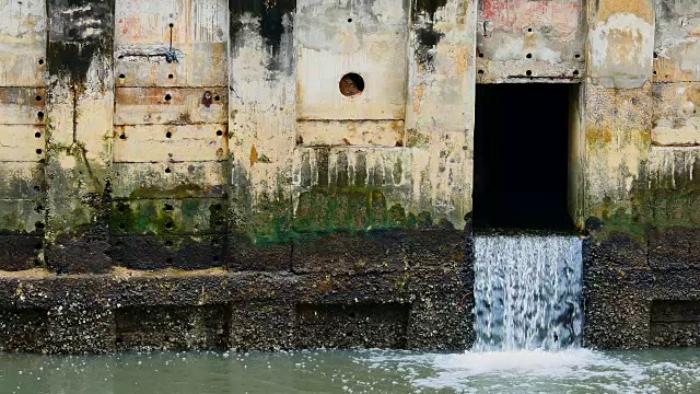 雨后日常生活视频。水从城里的一条运河流向大海。以水浸概念来排水及防止城市水浸。视频素材