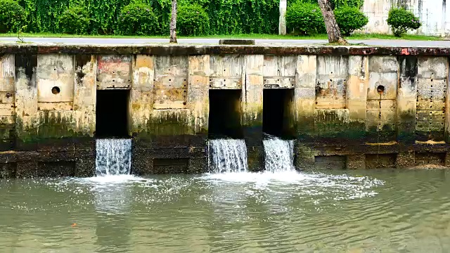 雨后日常生活视频。水从城里的一条运河流向大海。以水浸概念来排水及防止城市水浸。视频素材