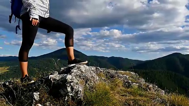 女人背着背包在山顶看日落，徒步女孩庆祝生活，风景优美的自然景观，享受假期旅行冒险视频素材