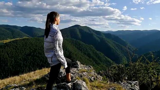 女人在山顶看日落，徒步女孩庆祝生活，风景优美的自然景观，享受假期旅行冒险视频素材