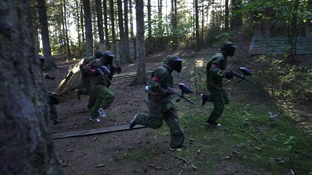 彩弹手在战场上奔跑在夏季森林射击游戏视频素材