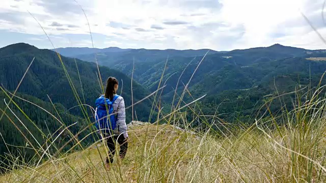 低角度女子徒步在山顶的日落徒步女孩庆祝生活风景自然景观享受度假旅行冒险，4k视频素材