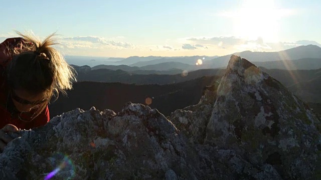 女性徒步旅行者在日出时爬过大海和高山视频素材