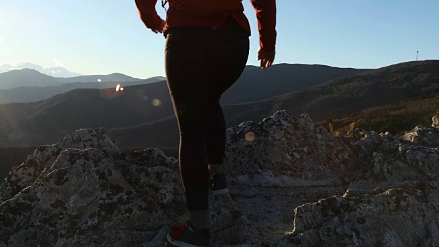 女性徒步旅行者在日出时爬过大海和高山视频素材