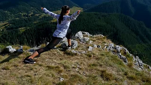 女人在山顶伸展在日落看徒步女孩庆祝生活风景自然景观享受度假旅行冒险，4k视频素材