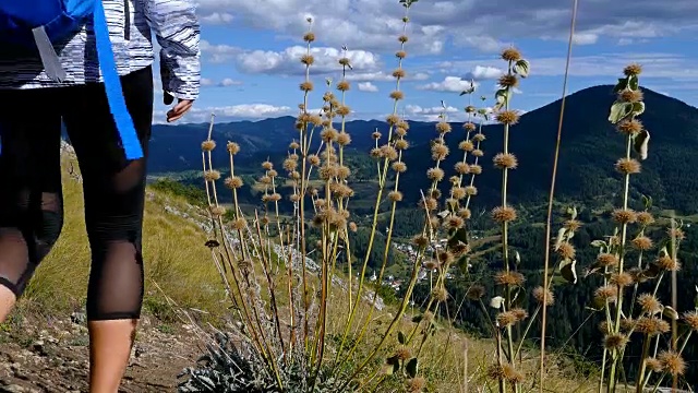 女子背包徒步旅行在山顶的日落景观徒步女孩庆祝生活风景自然景观享受假期旅行冒险，4k视频素材