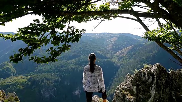 低角度的女子在山顶的日落徒步女孩庆祝生活风景自然景观享受度假旅行冒险，4k视频素材