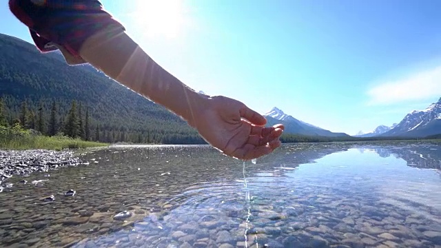 人们用手从山上的湖泊中舀取淡水视频素材