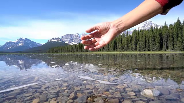 人们用手从山上的湖泊中舀取淡水视频素材