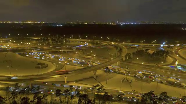 复杂的照明公路立交在冬天的晚上。空中hyperlapse。无人机是向后和向上飞行。建立了。视频素材