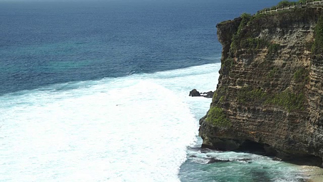 极端的海浪粉碎了印尼巴厘岛的乌鲁瓦图海岸视频素材