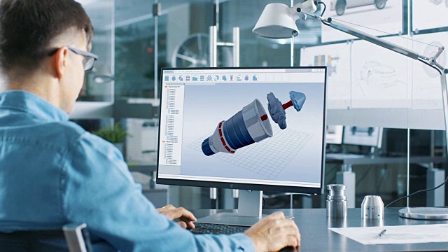 在个人电脑上工作的汽车工程师正在用CAD程序设计新型高效汽车发动机。他在明亮而现代的办公室工作。视频购买