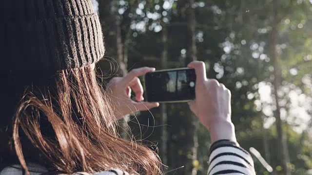 女游客用智能手机拍下全景风景。视频素材