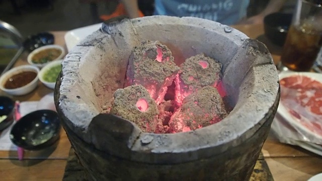 在泰式自助烧烤餐厅，把热锅放在木炭炉上。为烹饪食物做准备。视频下载