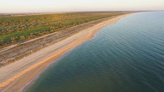 天线:日出时海浪冲进荒芜的海滩视频素材