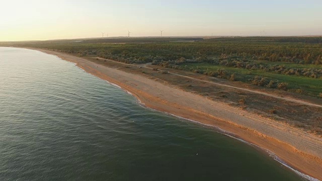 天线:日出时海浪冲进荒芜的海滩视频素材