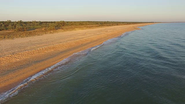 清晨，海浪涌向荒芜的海滩视频素材