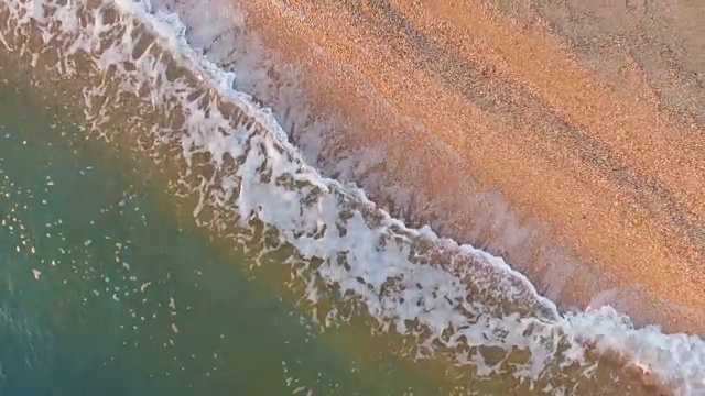 鸟瞰图:清晨海浪冲进荒芜的海滩，俯视图视频素材