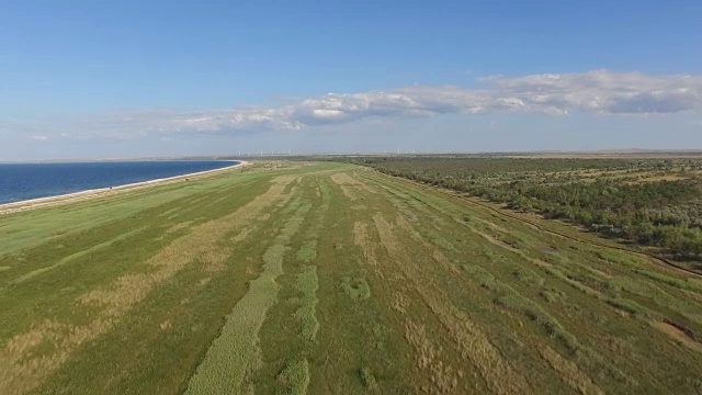 航拍图:蓝色海湾，海岸线沙质，植被繁茂视频素材