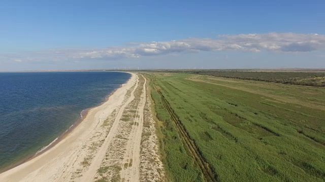 航拍图:蓝色海湾，海岸线沙质，植被繁茂视频素材