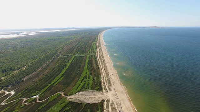 航拍图:蓝色海湾，海岸线沙质，植被繁茂视频素材