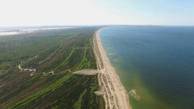 航拍图:蓝色海湾，海岸线沙质，植被繁茂视频素材