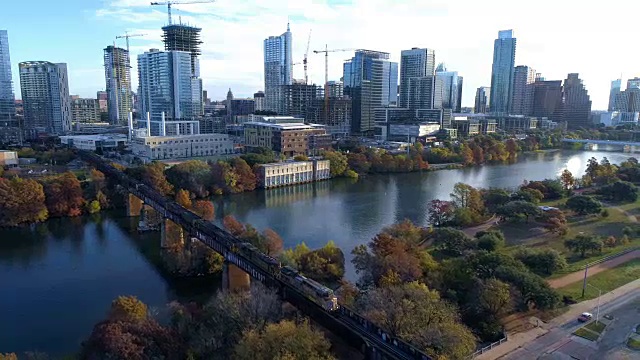 奥斯汀，德克萨斯州鸟瞰图戏剧性的火车跨越高架桥横跨镇湖在五彩缤纷的秋天视频素材