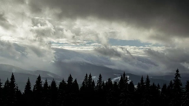 时间流逝，雷云移动上方的冬季山脉，暗松林前景自然景观视频素材