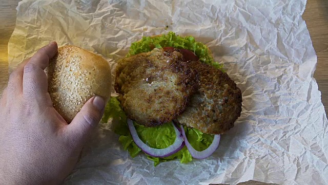 胖子在厨房里做饭吃大汉堡，不健康的生活方式视频素材