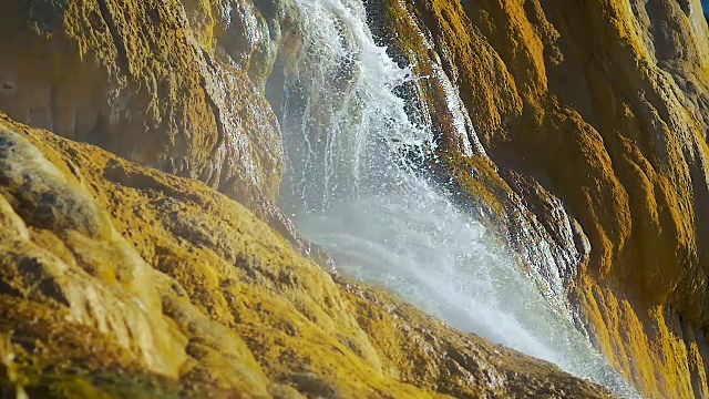 一个高山瀑布的特写慢慢流入大海的慢动作。视频素材