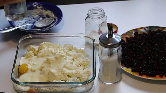 豆腐砂锅的准备。男子用醋浇灭苏打水，然后往容器里加入白软干酪。然后他加了葡萄干。视频素材