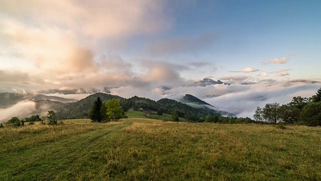 神奇的雾蒙蒙的早晨，云彩在美丽的风景在日出的秋天山脉。时间流逝间隔拍摄视频素材