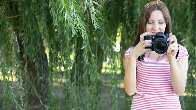 年轻女子与镜子相机在树的背景视频素材