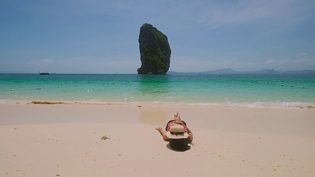 年轻的亚洲女子坐在美丽的海边休息。视频素材