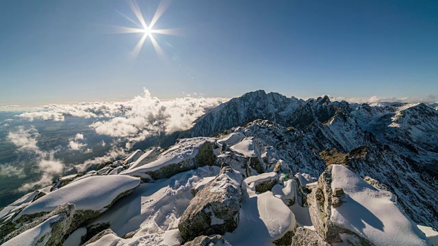 夕阳在雪山上空的云朵，岩石和雪的时间流逝视频素材