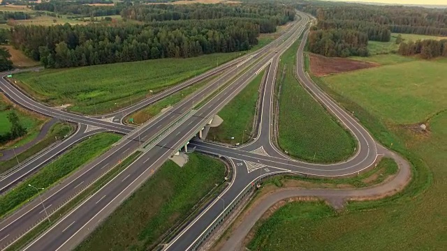 日落时分高速公路十字路口的汽车和卡车的空中摄影视频素材