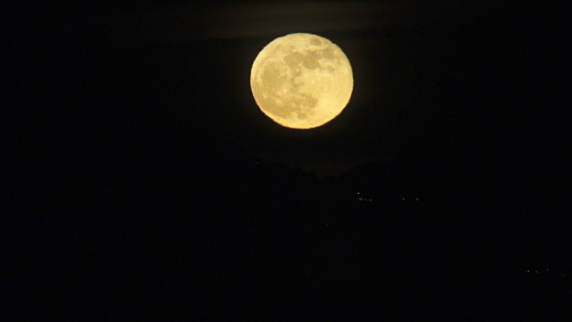 夜晚从山后升起的满月(或超级月亮)的时间间隔视频素材