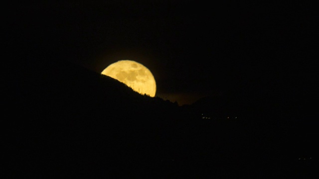 夜晚从山后升起的满月(或超级月亮)的时间间隔视频素材