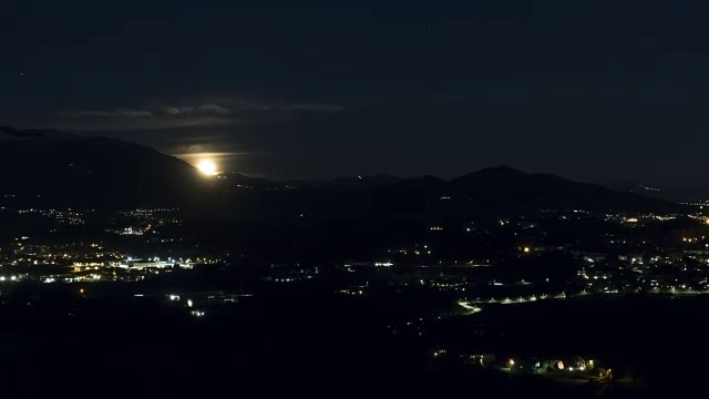 夜晚从山后升起的满月(或超级月亮)的时间间隔视频素材