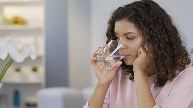 漂亮的混血女性喝着平静的水，享受着健康的生活方式视频素材