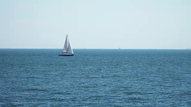 那艘扬帆航行的游艇漂浮在海上。视频素材