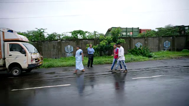 行驶在下雨的孟买公路上，远处是摩天大楼。视频素材