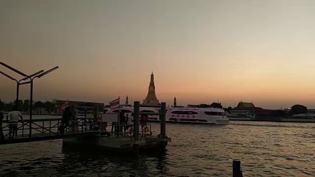 当地人和游客往返于湄南河。从快速船通过Wat Arun(寺庙的黎明)在曼谷，泰国。视频下载