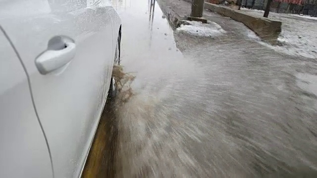 在洪水泛滥的道路上，汽车车轮高速溅水视频素材