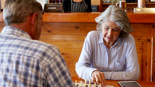 朋友们在4k酒吧边下棋边喝啤酒视频素材