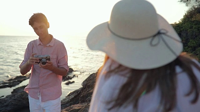 年轻男子在海滩上给他的女孩拍照视频素材